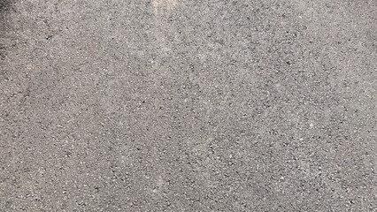 Close-up view of a textured asphalt surface with small stones and gravel.