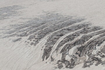 a glacier on the slopes of Elbrus covered with cracks in midsummer