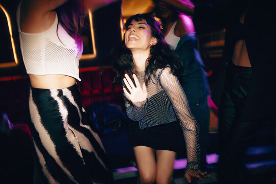 Group of friends enjoying a vibrant night out dancing in a club