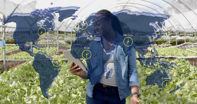 Female farming expert tapping tablet walking greenhouse map overlay clocks highlighting global sync