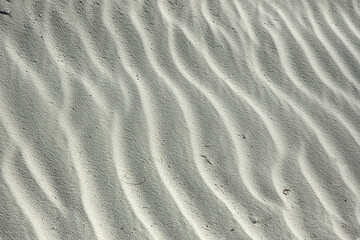 Wind blown white gypsum sand, looks like ripples in the water, frozen in time. Small waves created by the winds in White Sands National Park, Alamogordo, NM.