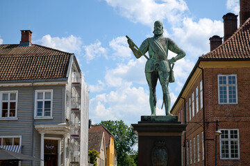 Bronze Statue in Historic Gamlebyen Frederikstad Surrounded by Traditional Scandinavian Architecture Under a Bright Summer Sky