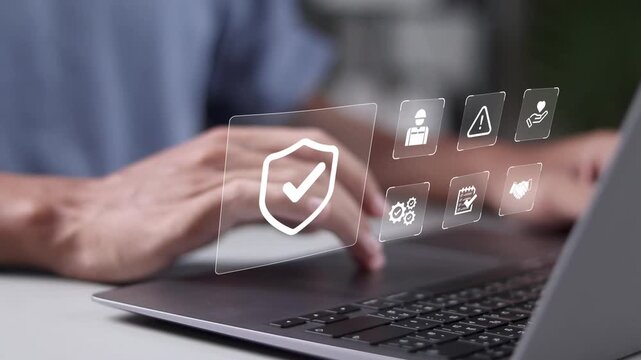 Work safety and compliance concept. Regulations and standard in industry. Person using laptop with safety icons on virtual screen for working standard process and zero accidents.