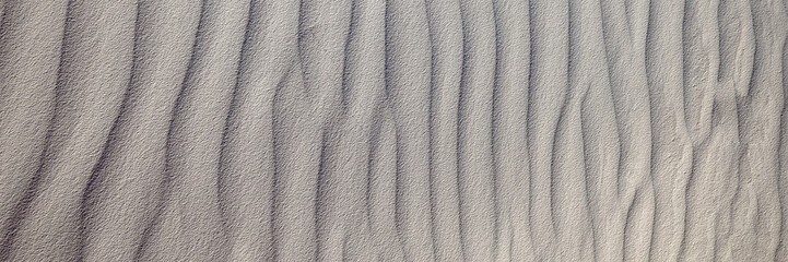 Wind blown white gypsum sand, looks like ripples in the water, frozen in time. Small waves created by the winds in White Sands National Park, Alamogordo, NM.