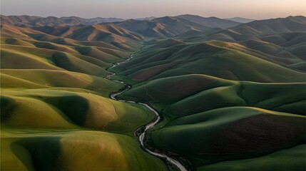 Fototapeta premium Lush green hills and winding river valley.