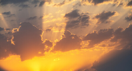 Bright orange sunset sky background with dramatic clouds. 