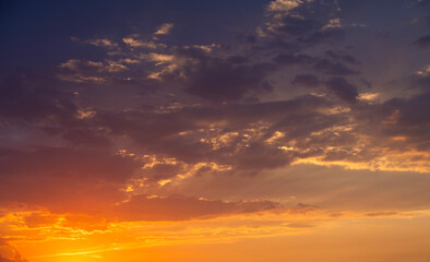 Fototapeta premium Bright orange sunset sky background with dramatic clouds. 
