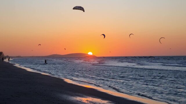 Paradisiacal sunset at Praia do Pre&aacute;, near Jericoacoara, with kitesurfers on the sea.