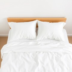 A clean and cozy white bed with two fluffy pillows and a wooden headboard