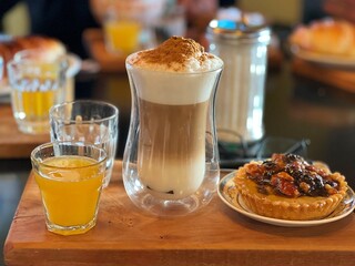 Cinnamon latte and pastries on a wooden board