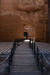 Wooden walkway through ancient brick archway at Roman ruins