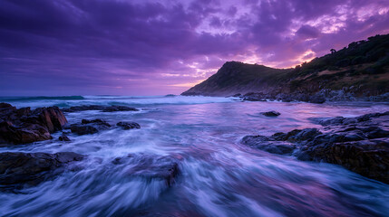 Purple twilight sky over rocky coastline with ocean waves purple sky