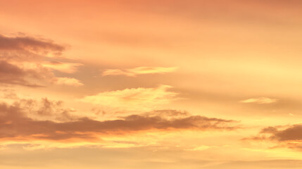 Fototapeta premium Golden sky with scattered clouds at sunset orange