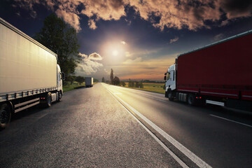 Large Transportation Truck on a highway road through the countryside at sunset