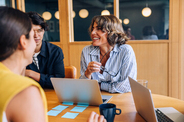 Smiling colleagues discussing ideas in a casual meeting atmosphere