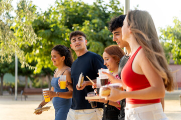Generation z friends enjoying street food and drinks together
