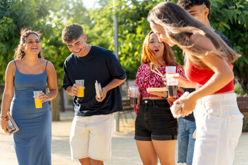 Group of young adults enjoying street food and drinks together