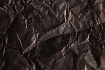 Wrinkled dark paper texture with shadows
