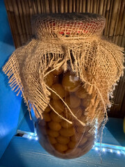 Jar of yellow cherry plums covered with burlap