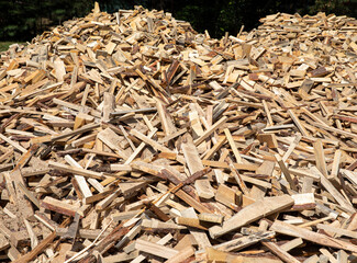 A large pile of finely chopped firewood in the summer afternoon.