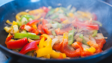 Vibrant mix of sautéed bell peppers and onions steaming fresh from the pan. Perfect for healthy recipe content, vegan blogs, and food photography.