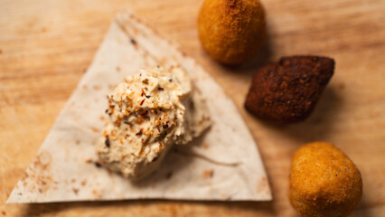 Creamy hummus with flaky chicken pastries (fatayer-style) and crispy kibbeh. Authentic Middle Eastern sharing plate for food blogs and gourmet menus.