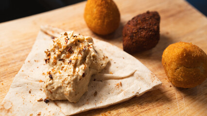 Creamy hummus with flaky chicken pastries (fatayer-style) and crispy kibbeh. Authentic Middle Eastern sharing plate for food blogs and gourmet menus.