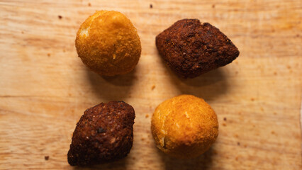 Golden fried kibbeh and Brazilian chicken coxinha pastries on rustic board. Perfect for cultural food content, party menus, and street food photography.