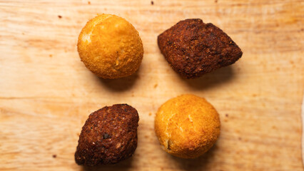 Golden fried kibbeh and Brazilian chicken coxinha pastries on rustic board. Perfect for cultural food content, party menus, and street food photography.