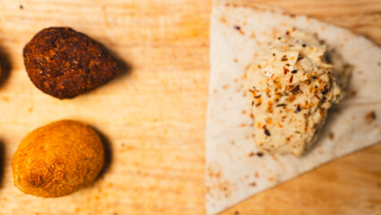 Creamy hummus with flaky chicken pastries (fatayer-style) and crispy kibbeh. Authentic Middle Eastern sharing plate for food blogs and gourmet menus.