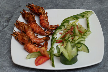 Spicy Tandoori Prawns with a Fresh Salad Garnish on a White Plate closeup view of Indian seafood cuisine