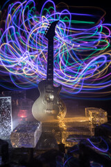 Music Concept: Guitar Miniature on a Dark Background with Vivid Light, Smoke, and Fire Effects. Golden electro guitar under a Dramatic Spotlight.