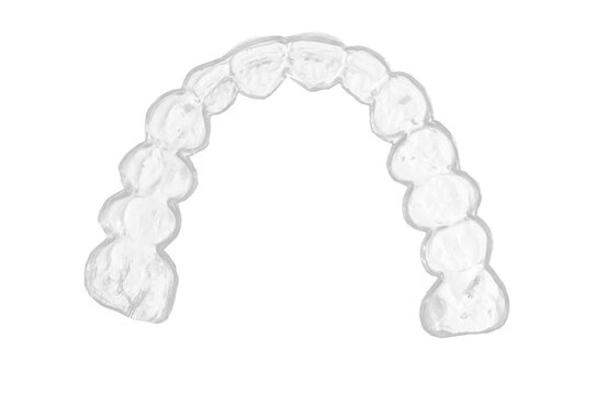 Transparent dental mouth guard with smooth clear plastic surface and detailed tooth impressions, photographed from an angled top side view on white background with soft even lighting in studio