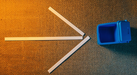 Top view of paper strips and blue toy trashcan