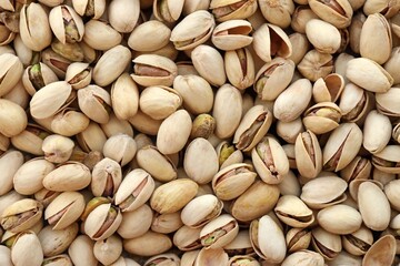 Tasty unpeeled pistachios as background, top view flat lay background