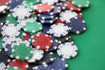 Casino gaming background with stacks of betting chips of different colors on green gaming mat
