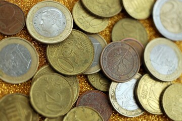 Big amount of euro coins on golden glitter background