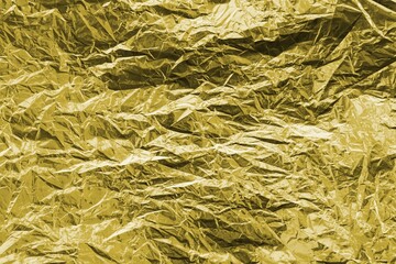 Golden crumpled foil texture on flat surface