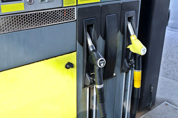 Closeup of Fuel Pump Handles for Diesel and Gasoline at Gas Station.Fuel pump handles in yellow and...