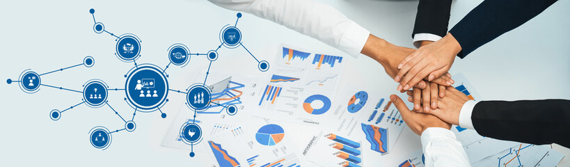 A dynamic scene depicting teamwork in action, showcasing hands united over business analysis...