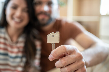 Happy couple holding new house key after buying home