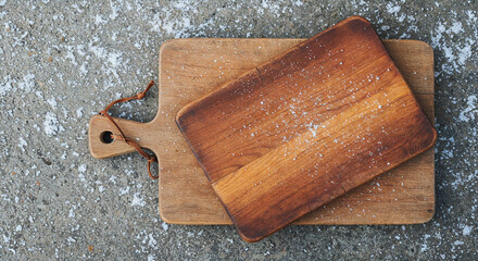 top view of brown wooden chopping boards on weathered grey background