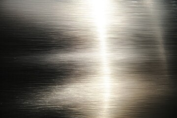 Fototapeta premium Minimalist brushed metal surface with fine horizontal lines and gentle light reflections, evoking industrial strength and modern design elegance.