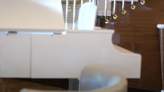 Piano keyboard video shooting. Cozy white interio. White piano in the restaurant