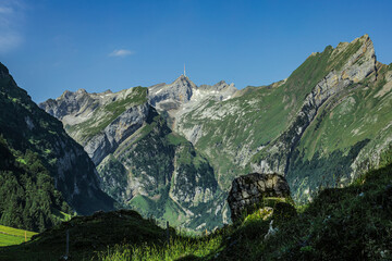 Breathtaking view of the iconic Santis peak rising above rugged alpine valleys, captured from the scenic hiking trails near Seealpsee in Appenzell, Switzerland, on a clear summer day. © The Great Capture