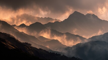 Moody dramatic mountain range with layered fog and warm sunset light.