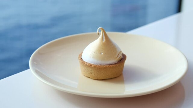 Lemon meringue tart of delicious tart dessert with meringue swirl on the top, coffee break with confectionery in a cafe. High quality 4k footage