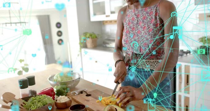 Close-up woman halving avocado, chopping pepper on wooden board, activating smart kitchen icons