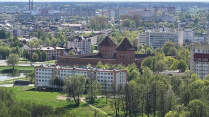 Obraz premium Lida Castle in the town of Lida, Belarus. Panoramic view of Lida and Lida medieval castle. The castle in the middle of a modern city.