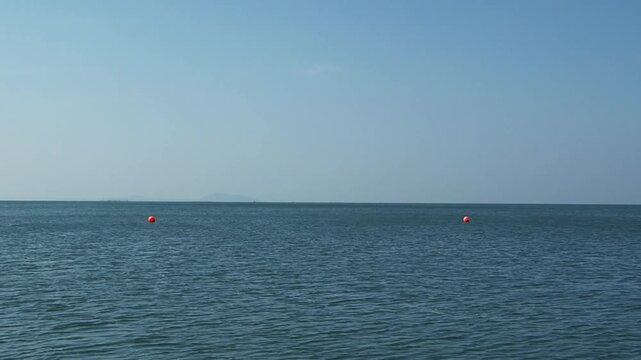 Wide-angle vedeo footage of calm ocean under a clear blue sky, with the horizon line stretching across the frame ideal for sea nature, relaxation, and travel themes and nature lovers.